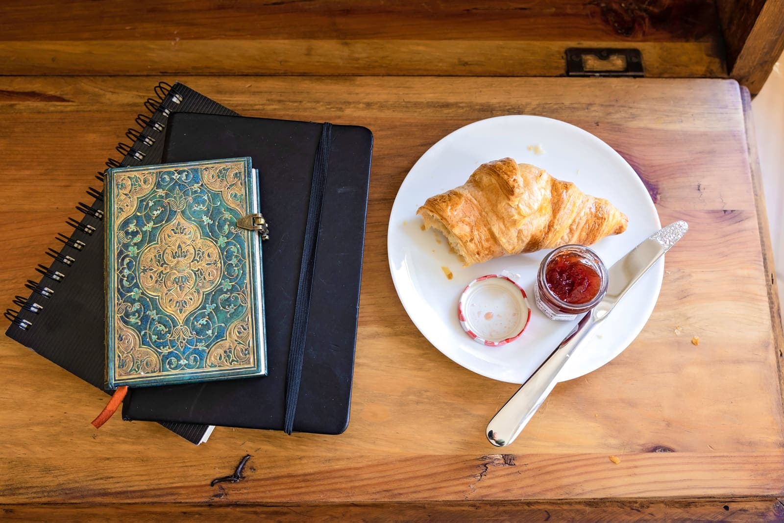 Journals and notebooks with a croissant