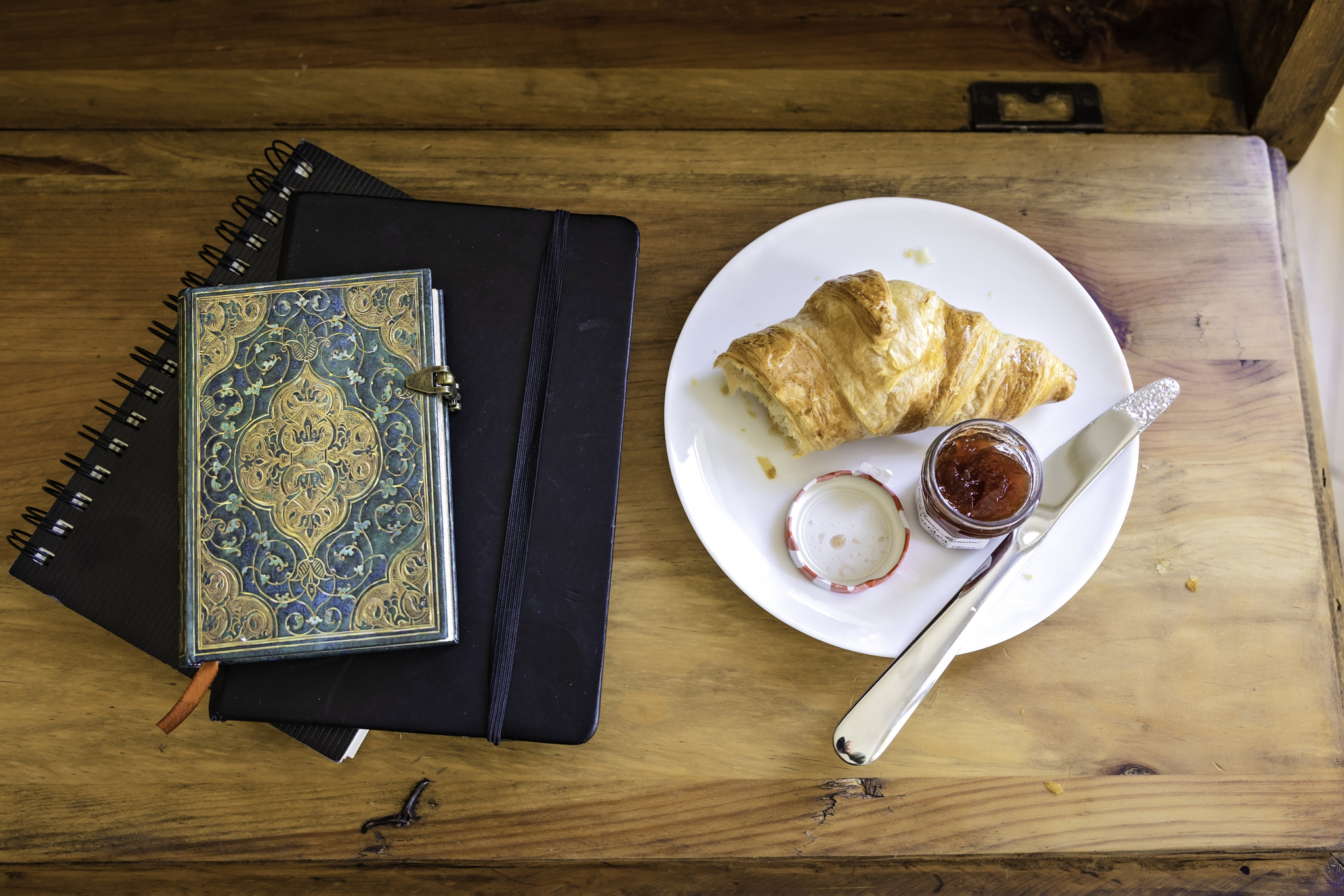 Journals and notebooks with a croissant